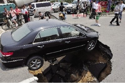 4日，南昌市昌南大道與迎賓北大道交叉口附近路面突然發(fā)生塌陷，一輛過路小轎車被卡在洞口處。圖/新華社
