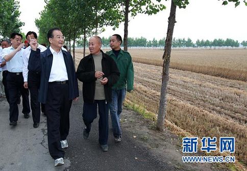 這是6月9日，溫家寶在長葛市石象鄉(xiāng)坡李王村的田間小路上與坡李王村支部書記李福成邊走邊聊。新華社記者龐興雷攝