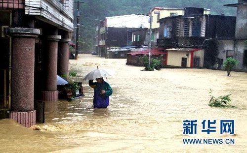 10月21日，臺(tái)灣宜蘭縣蘇澳地區(qū)居民在洪水中艱難出行。新華社發(fā) 
