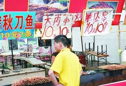 被查后，美食街上的'羊肉串'的'羊'字被涂抹了。