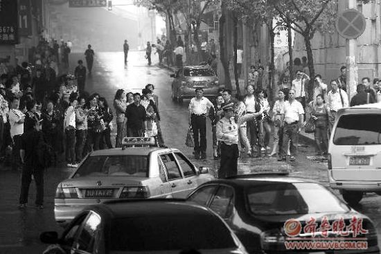  8日，在青島15中考點外，家長排起人墻堵路，交警只能指揮途經車輛繞行。 本報記者 楊寧 張曉鵬 攝