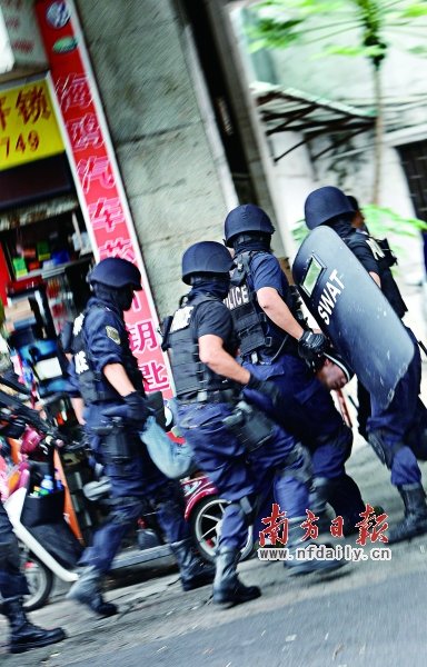 特警將嫌疑人（紅圈內(nèi)）押上警車。