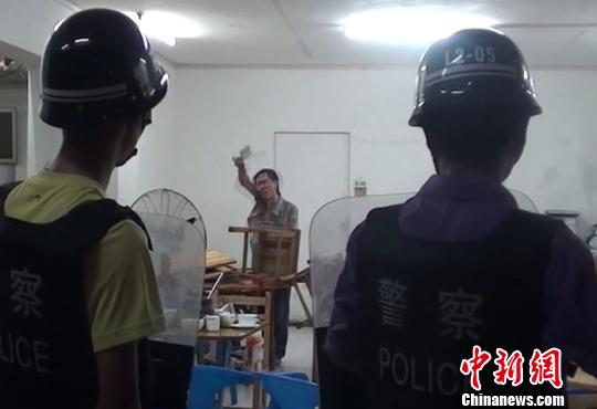圖為涉嫌販毒的男子持菜刀在宵夜店與民警對峙。 劉志強(qiáng) 攝