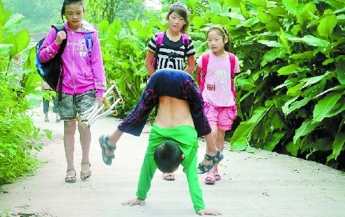 倒立行走去上學 堅強癱瘓男孩感動網(wǎng)友。圖據(jù)山東商報