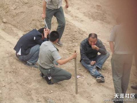 陜AWK707的西安城管執(zhí)法車和6名穿制服的城管，手持棍棒，在郊外毆打兩名倒地男子。 