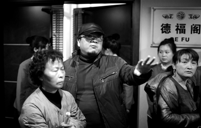 昨日，在河北香河天下第一城，相關(guān)負責(zé)人（左二）走出會議室與參加演出的老人們溝通。