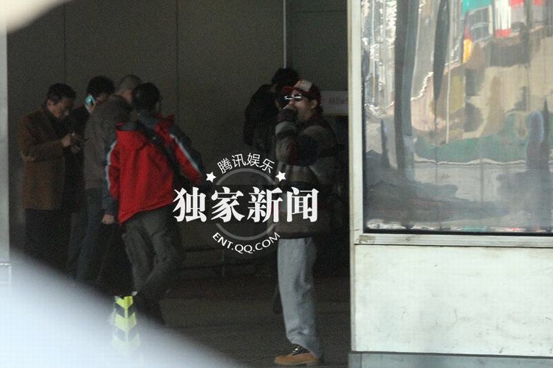 張默抵京機(jī)場(chǎng)過煙癮 神秘美女同車離去