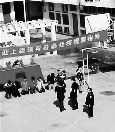 網(wǎng)上熱傳的7名學生在迎接領(lǐng)導條幅下面下跪的照片。