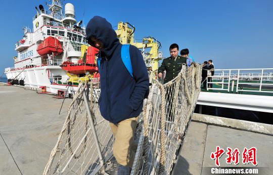圖為24名“驢友”的“導(dǎo)游”被邊防的工作人員帶下船接受調(diào)查。 駱云飛 攝