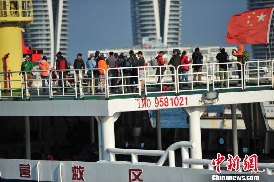 圖為24名“驢友”的“導(dǎo)游”被邊防的工作人員帶下船接受調(diào)查。 駱云飛 攝