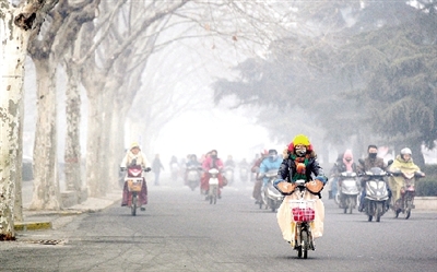昨天上午，中原路，行人在霧霾中騎車出行，很多行人戴上了口罩。