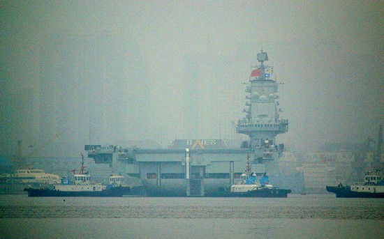 資料圖：大連港口大霧彌漫，中國首艘航母“遼寧艦”徐徐離開港口。