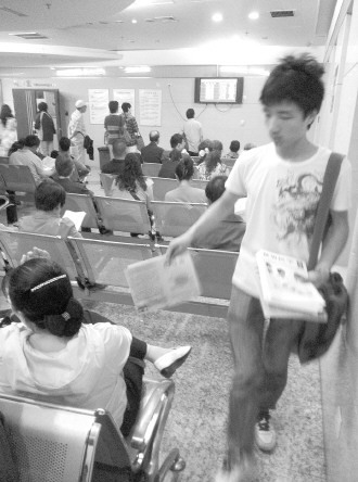 發(fā)報人員正在候診大廳散發(fā)虛假宣傳品。 本報記者 楊晉峰 攝